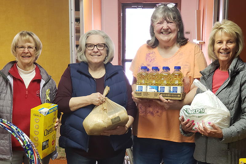 Four women holding food pantry donations