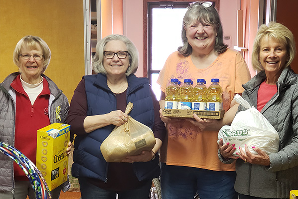 Four women holding domations for the Waushara County Food Pantry